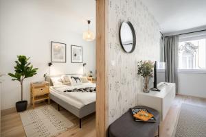 1 dormitorio con cama y espejo en Cosy Tolnai street Apartments, en Budapest