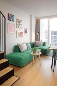 a living room with a green couch and a table at Zoku Paris in Paris