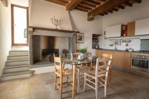 cocina con mesa, sillas y chimenea en Colle del Vento, en Todi