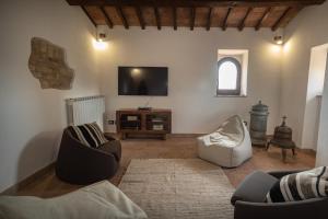 sala de estar con 2 sillas y TV de pantalla plana en Colle del Vento, en Todi