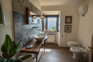 y baño con lavabo, aseo y espejo. en Colle del Vento, en Todi