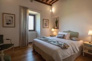 a bedroom with a large bed and a chair at Colle del Vento in Todi