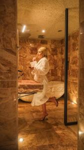 Una donna con un vestito bianco seduta su un letto di Olenda Cappadocia Hotel a Üçhisar