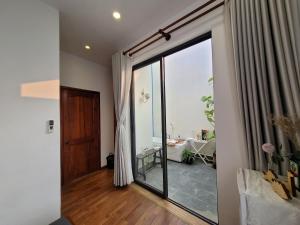 MIHA Villa & Stay في Cái Răng: غرفة معيشة مع باب زجاجي منزلق كبير