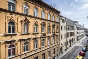 un grand bâtiment avec de nombreuses fenêtres donnant sur une rue dans l'établissement Cosy Tolnai street Apartments, à Budapest