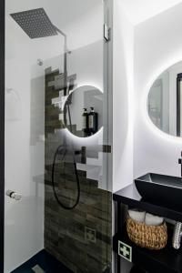 een badkamer met een zwarte wastafel en 2 spiegels bij Regras 45 Building B by LovelyStay in Porto