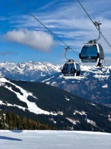 two ski lifts flying over a snow covered mountain at One Bedroom Apartment with Panoramic views in Piesendorf