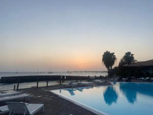 - une piscine au coucher du soleil à côté de la plage dans l'établissement Apt14 Porto Antigo 1 with Pool and Beach views, à Santa Maria