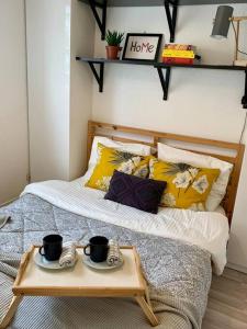 a bed with two coffee cups and a tray on it at Hiker's spot - Parking A/C City Center in Grenoble