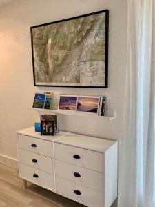 a white dresser with a painting on the wall at Hiker's spot - Parking A/C City Center in Grenoble