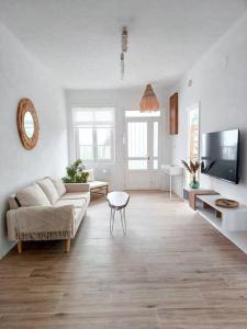 sala de estar con sofá y TV en Casa Maruxa, en A Coruña