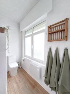 a bathroom with a toilet and a window and towels at Casa Maruxa in A Coruña