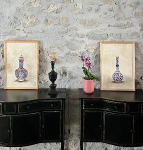 une table avec deux photos et deux vases sur elle dans l'établissement LA COUR CARREE, à Carcassonne