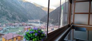 a window with a view of a town and mountains at Helen Suit in Çaykara