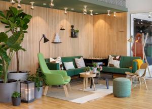 een woonkamer met groene banken en planten bij Zoku Paris in Parijs