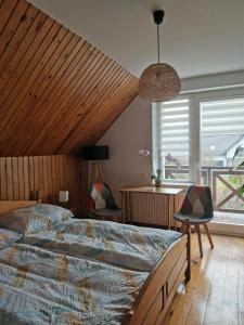 a bedroom with a large bed and a large window at Apartament Forest in Mysłakowice