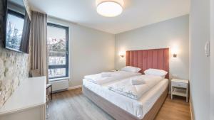 Ένα ή περισσότερα κρεβάτια σε δωμάτιο στο Apartamenty Sun & Snow Okrzei