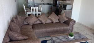a living room with a brown couch and a table at Jordy 1 your home away from home in Margate