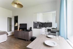 a kitchen and living room with a table and chairs at Forenom Serviced Apartments Helsinki Lapinlahdenkatu in Helsinki