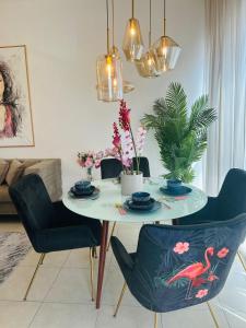 een eettafel met stoelen en een tafel met een vogel erop bij 1-Bedroom Apartment Rental Unit With Pool in Dubai Land Residence Complex Dubai Al Ain Road in Dubai