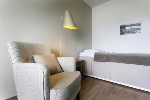 a living room with a chair and a bed at Forenom Serviced Apartments Helsinki Lapinlahdenkatu in Helsinki