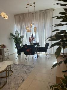 a living room with a dining table and chairs at 1-Berdroom Apartment Rental Unit With Pool in Dubai Land Residence Complex in Dubai