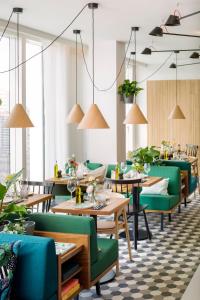 a dining room with tables and green chairs at Zoku Paris in Paris