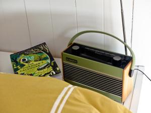 een radio naast een bed met een zak bij Oak Shepherds Hut in Wootton Fitzpaine