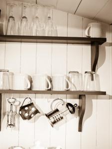 a kitchen with glasses and dishes on shelves at Oak Shepherds Hut in Wootton Fitzpaine
