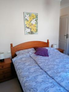 a bedroom with a bed with a blue comforter at Casa Ela in Caleta de Interián