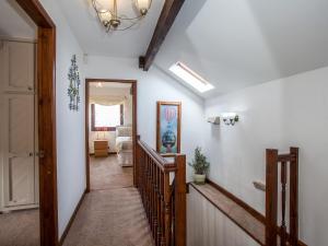 a hallway with a stairway leading to a room at Honeysuckle Cottage - 27880 in Elton