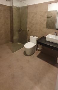 a bathroom with a toilet and a shower and a sink at MUDAN hotel and suite in Islamabad