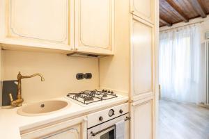 a kitchen with a stove and a sink at [TICINESE-DUOMO ELEGANTE] Centrale con A/C in Milan