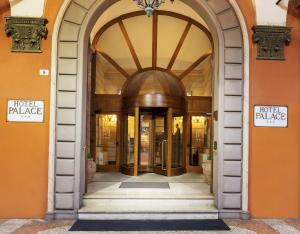 łukowe drzwi do budynku hotelowego pałacu w obiekcie Hotel Palace Bologna Centro w Bolonii