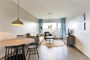a kitchen and living room with a table and chairs at Forenom Serviced Apartments Helsinki Lapinlahdenkatu in Helsinki