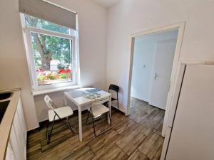 柏林的住宿－Nice apartment in Berlin Pankow 8，窗户客房内的小白色桌子和椅子