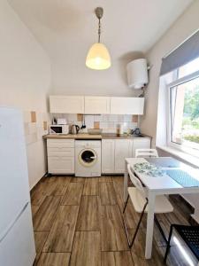 柏林的住宿－Nice apartment in Berlin Pankow 8，厨房配有白色橱柜、桌子和水槽。