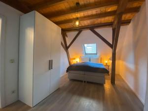 - une chambre avec un lit dans une pièce dotée de plafonds en bois dans l'établissement Ferienwohnungen Annweiler am Trifels, à Annweiler am Trifels