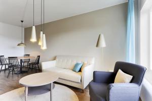 a living room with a couch and chairs and a table at Forenom Serviced Apartments Helsinki Lapinlahdenkatu in Helsinki