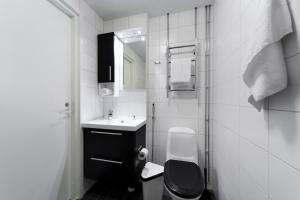 a white bathroom with a toilet and a sink at Forenom Serviced Apartments Helsinki Lapinlahdenkatu in Helsinki +28 photos