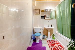 bagno con servizi igienici e lavandino con tappeto viola di House 220 a Londra