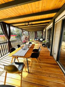 una terrazza in legno con tavolo e sedie. di Brand New Mobile House - Soline Beach a Biograd na Moru