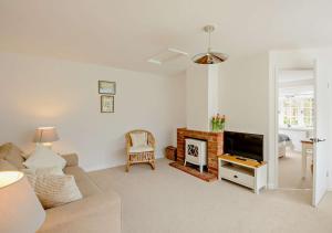 a living room with a couch and a tv at Chantry Place in Long Melford