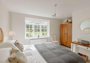 a white bedroom with a large bed and a window at Chantry Place in Long Melford