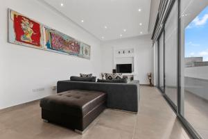a living room with a couch and a tv at Glabur Stays - The Luxurious 3 BDR - Cozy apt Newly Renovated, Nicosia City in Ayios Dhometios