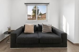 un sofá en una sala de estar con ventana en Glabur Stays - The Luxurious 3 BDR - Cozy apt Newly Renovated, Nicosia City en Ayios Dhometios