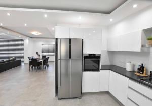 cocina con nevera y comedor en Glabur Stays - The Luxurious 3 BDR - Cozy apt Newly Renovated, Nicosia City en Ayios Dhometios