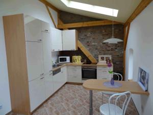 a kitchen with white cabinets and a table with chairs at Nitschke "Zum Nusshof" in Ahrensfelde