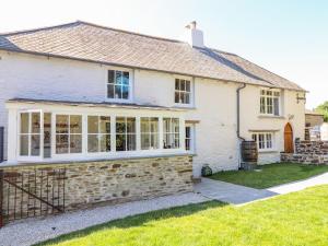 a white house with windows and a yard at Trewince Manor Cottage in Truro