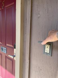 a persons hand is reaching for a lightswitch on a door at Mountain Harbor Queen Guest Room on Lake Ouachita in Mount Ida